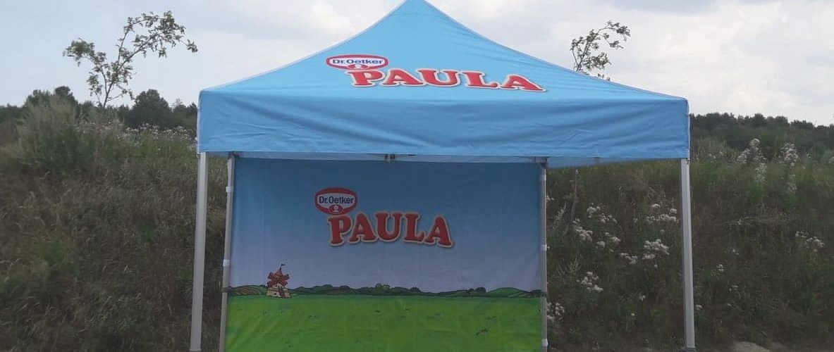Dr. Oetker Paula sininen teltta ulkotilaesittelyssä, maisemapainotteisella grafiikalla