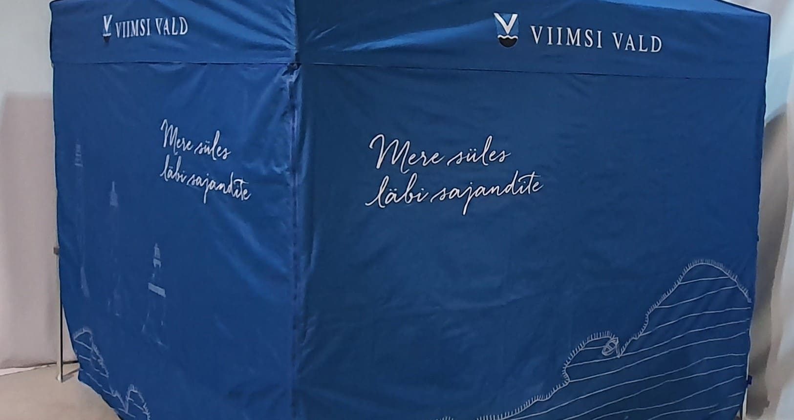 Sininen telttamainonta "Viimsi Vald" logolla ja tekstillä, rannikon kuvituksella