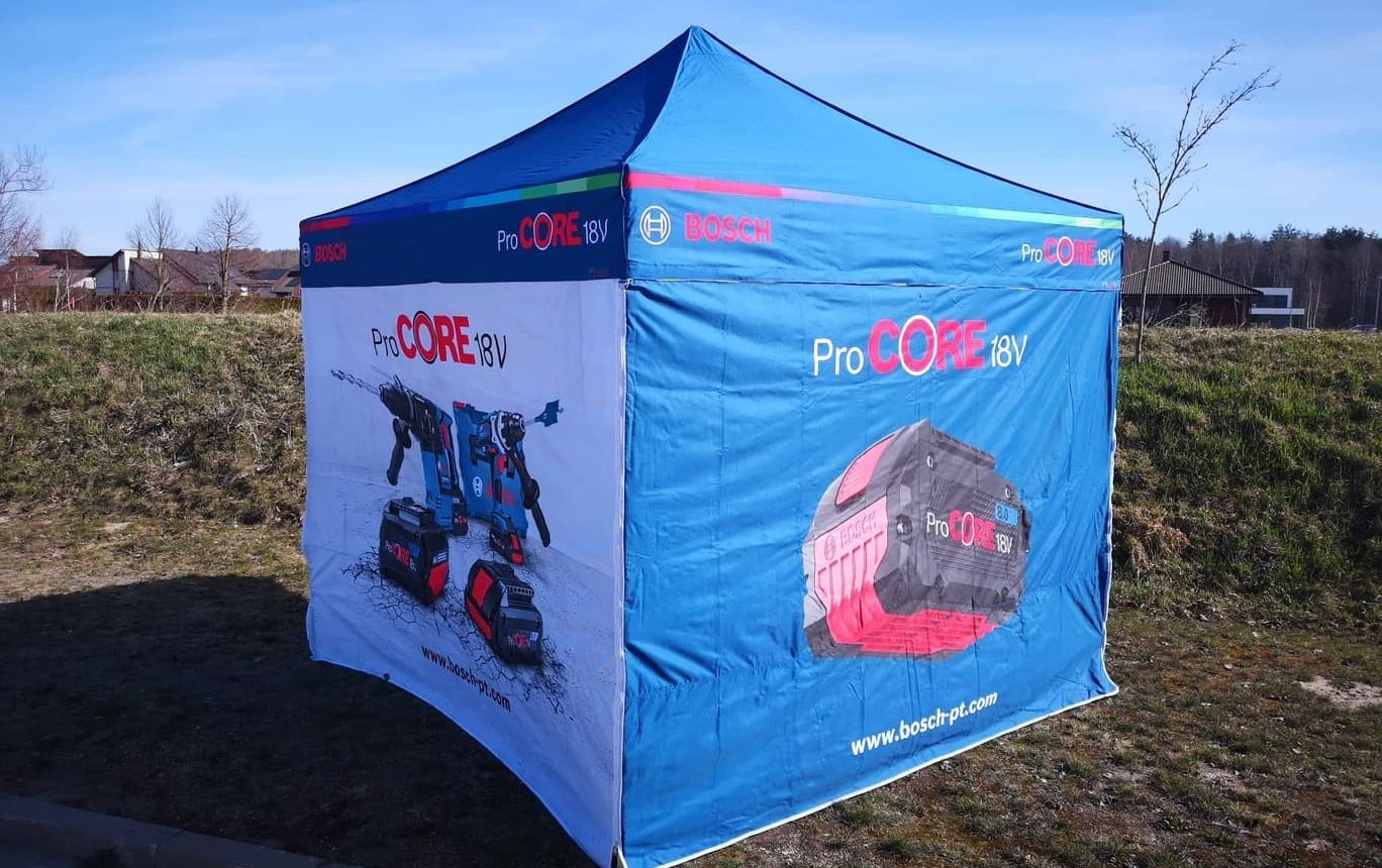Bosch ProCORE 18V teltta -näyttelyteltta maastossa. Sininen ja valkoinen mainosteltta, jossa