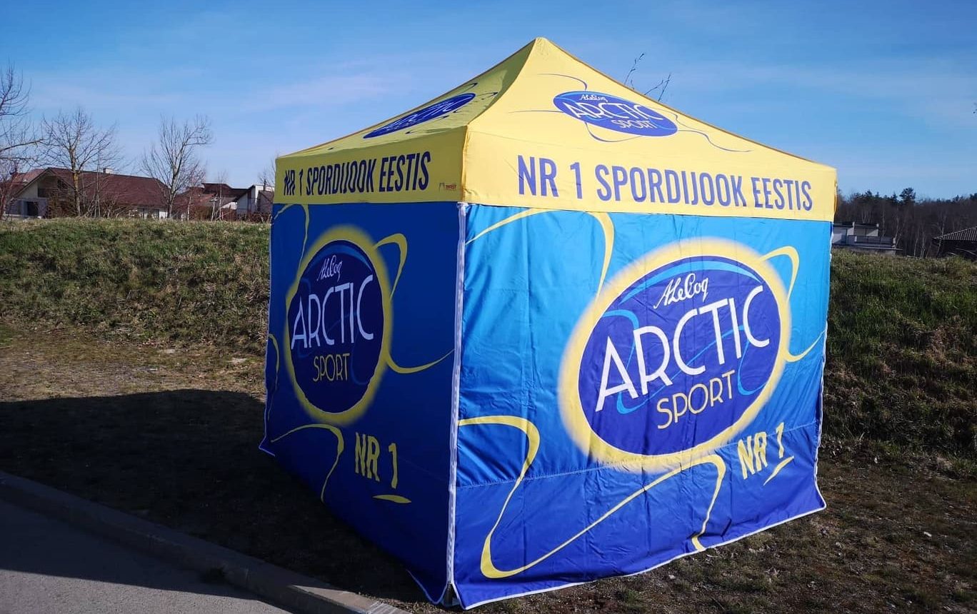 Keltisen katon ja sinisen seinän omaava mainosteltta, jossa näkyy Arctic Sport -logo ja "NR 1