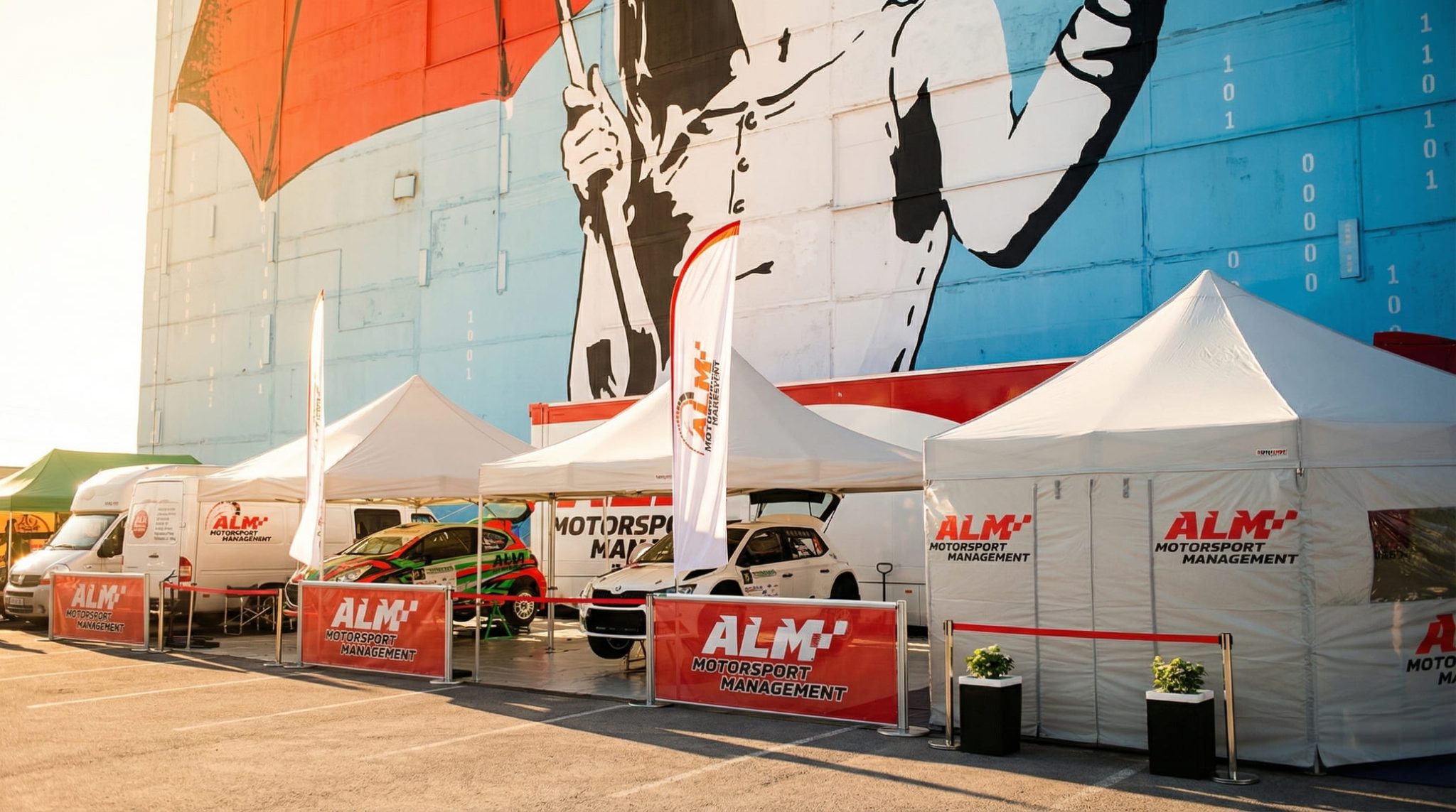 Valkoisia pop-up telttoja ALM Motorsport Management -brändäyksellä motorsporttitapahtumassa, autoja