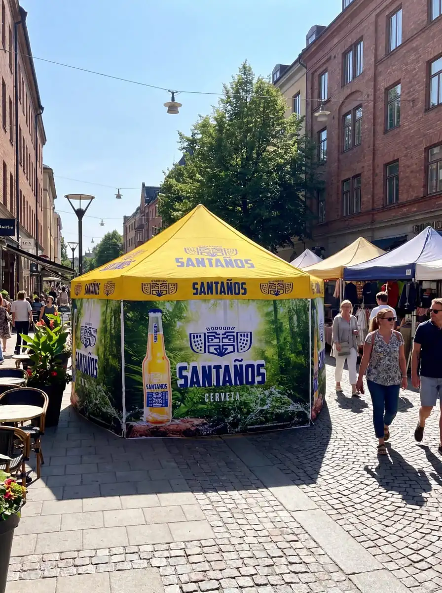 Keltainen Santaños-olutkauppatentin mainostensori katumarkkinoilla ihmisten ympäröimänä